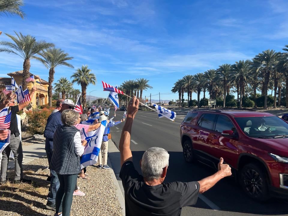 Residents wave flags along Highway 111 in Indio during a pro-Israel rally organized by the local chapter of StandWithUs, an international organization focused on antisemitism and Israel. The rally focused on the release of the remaining hostages held by Hamas.