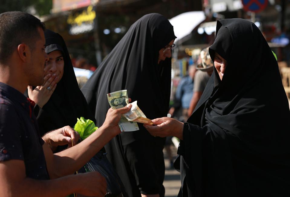 Iranian Shiite pilgrims use Iranian currency for shopping outside the holy shrine of Imam Hussein ahead of the Arbaeen festival in Karbala, Iraq, Friday, Oct. 18, 2019. The holiday marks the end of the forty day mourning period after the anniversary of the martyrdom of Imam Hussein, the Prophet Muhammad's grandson in the 7th century. (AP Photo/Hadi Mizban)