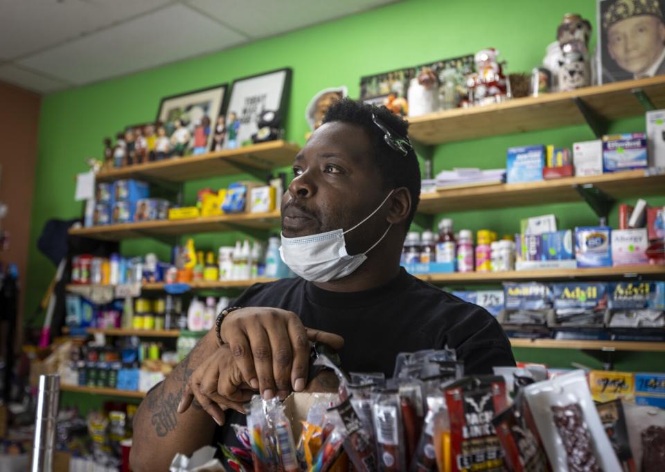 Employee Mark Burton looks out over Skid Row while waiting for customers at Danny Park's Skid Row People's Market