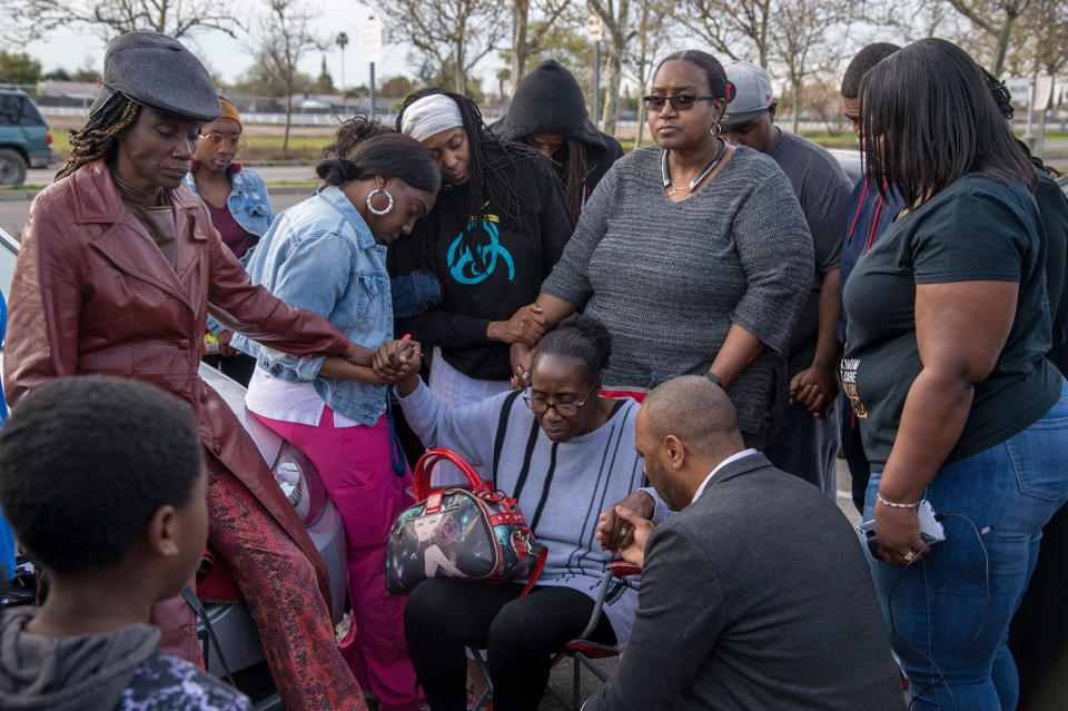 <p>Mar 19, 2018 – Sacramento, California, U.S. – Sequita Thompson, grandmother of Stephan Clark, is surrounded by family as they pray in the parking lot of the Meadowview Light Rail Station, in Sacramento, Calif., on March 19, 2018. Clark was killed by police the night of March 18, in the backyard of his grandmother’s home. (Photo: Jose Luis Villegas/Sacramento Bee via ZUMA Wire) </p>