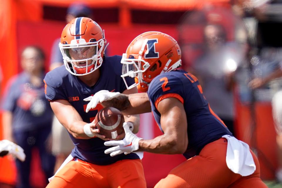 Illinois quarterback Tommy DeVito hands off to running back Chase Brown during the first half of an NCAA college football game against Wyoming, Saturday, Aug. 27, 2022, in Champaign, Ill. (AP Photo/Charles Rex Arbogast)