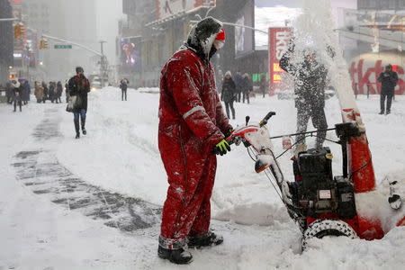 A worker uses a snowblower to clear snow from Times Square in the Manhattan borough of New York January 23, 2016. REUTERS/Shannon Stapleton