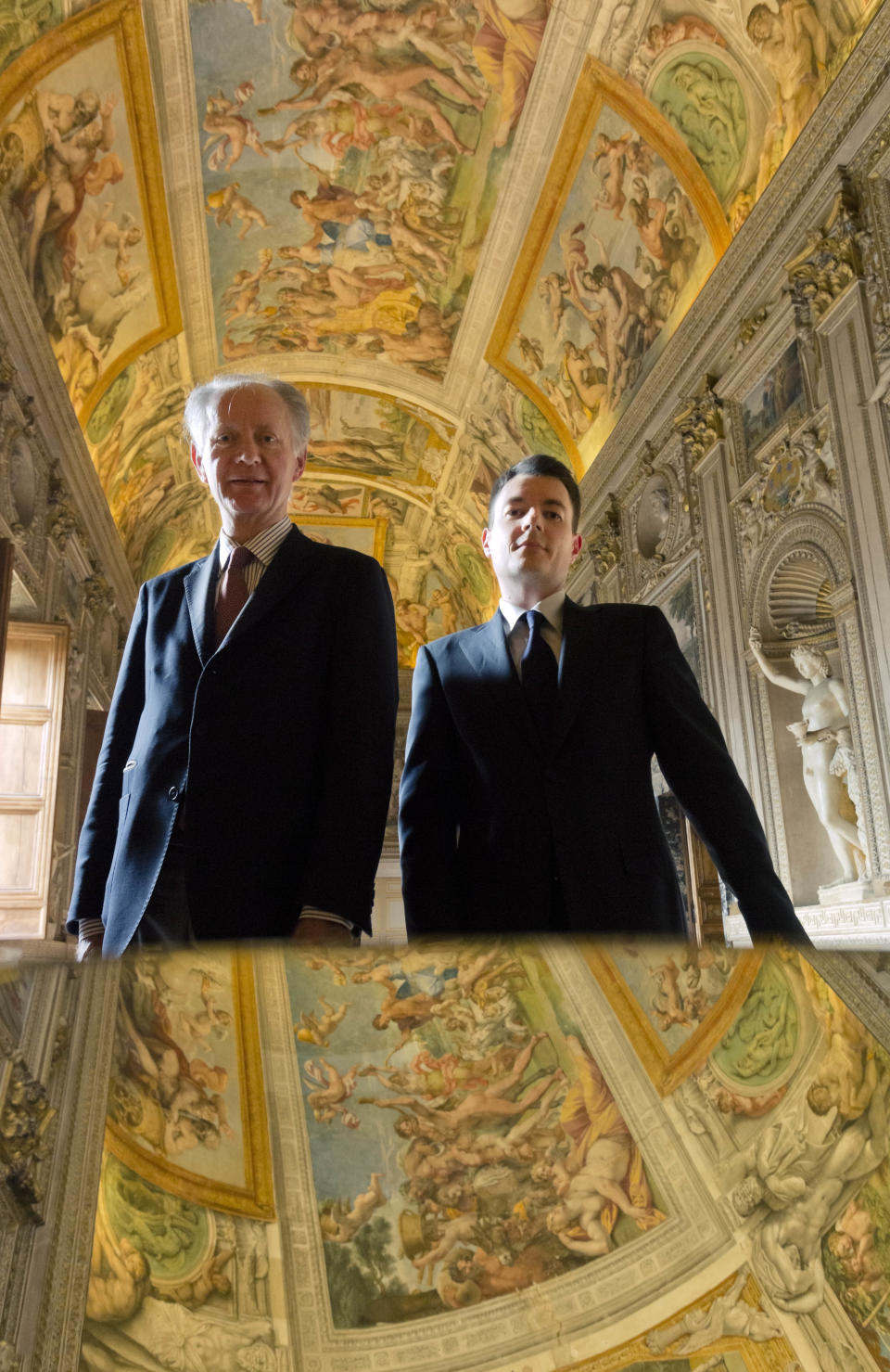 President of World Monuments Fund Europe, Bertrand du Vignaud, left, poses with Embassy Counsellor Erkki Maillard in front of a mirror strategically positioned to allow visitors to admire the splendour of the frescoed ceilings of the Carracci Gallery in the Farnese Palace that hosts the French Embassy in Rome, Wednesday, Feb. 26, 2014. The World Monuments Fund Europe will allocate some 800 million Euros for the restoration of the about 140 square meters of 16th century frescoes by Annibale and Agostino Carracci that will begin mid March and are expected to be completed in 2015. (AP Photo/Domenico Stinellis)