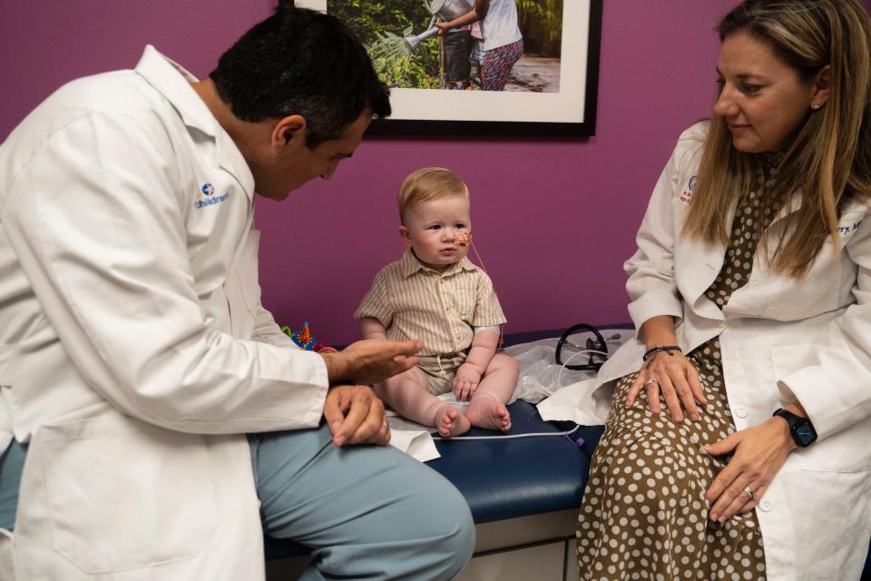 Dr. Carlos Mery, left, and Dr. Chesney Castleberry sit with Elias Robinson-Rodriguez after a checkup for the boy's partial heart transplant in June at Dell Children's Medical Center. The Dell Children's team was one of the first in the world to do a partial heart transplant.