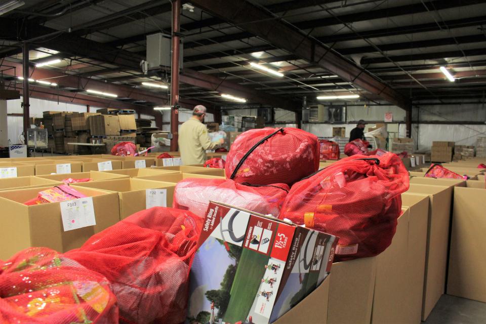 Volunteers retrieve bags of gifts from marked bins inside the Salvation Army warehouse in Fort Smith Dec. 16.