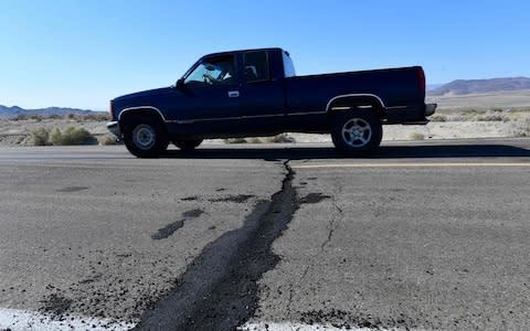 A vehicle drives over a patched up crack after the first quake - Credit: FREDERIC J BROWN/AFP/Getty Images