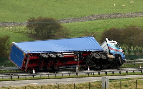 A HGV becomes a victim of the gale force winds, as this high sided vehicle is toppled on the M6 in Cumbria - Credit: Paul Kingston/North News