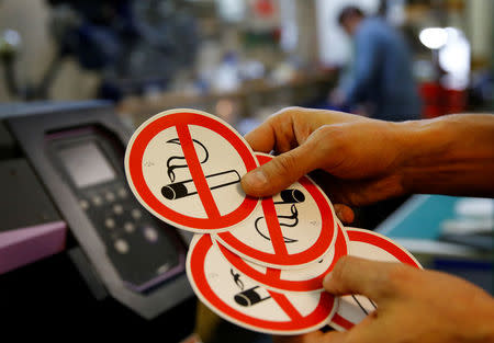 An employee shows no smoking signs in the Karas printing shop in Vienna, Austria March 8, 2018. REUTERS/Leonhard Foeger