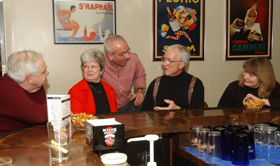 Mino Spada, owner of Mino's Cucina Italiana in Wausau (standing), talks with customers on Feb. 8, 2003, at the restaurant's bar. The restaurant opened in November 1993 and operated for 18 years, closing its doors in July 2011.