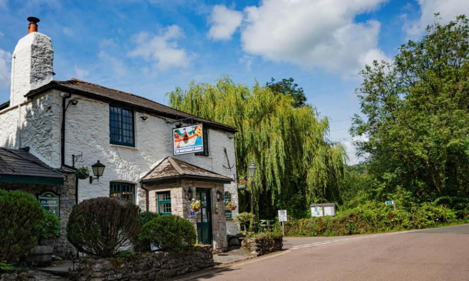 The white exterior of Watermans Arms Public House, with trees in the background