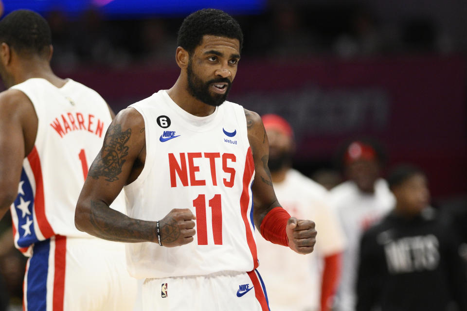 Brooklyn Nets guard Kyrie Irving (11) reacts after he scored during the first half of an NBA basketball game against the Washington Wizards, Monday, Dec. 12, 2022, in Washington. (AP Photo/Nick Wass)