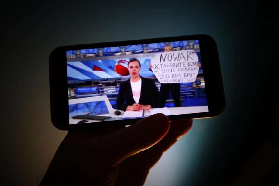 The evening news broadcast on the main Russian news channel, Channel 1 is seen on a mobile phone as it is interrupted by a woman protesting the war in Ukraine in this illustration photo on 15 March, 2022 in Warsaw, Poland. Marina Ovsyannikova, an employee of the network ran onto the stage with a sign reading 'No War' and 'They're lying to you here'. (Photo by STR/NurPhoto via Getty Images)