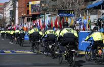 Boston Police officers on bicycles ride across the finish line before the 118th Boston Marathon Monday, April 21, 2014 in Boston. (AP Photo/Elise Amendola)