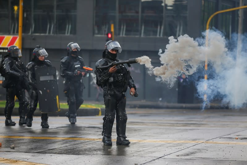 Policías disparan gases lacrimógenos para dispersar manifestantes durante una jornada de protesta en Bogotá