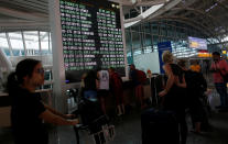 <p>Passengers stand near the flight information board after Indonesian and regional authorities heightened flight warnings, following the eruption of Bali’s Mount Agung volcano at Ngurah Rai International airpot in Bali, Indonesia, Nov. 26, 2017. (Photo: Nyimas Laula/Reuters) </p>