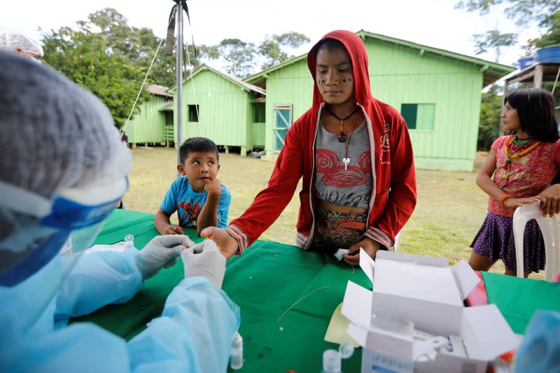 Member of the Brazilian Armed Forces medical team takes COVID-19 tests from a child from the indigenous Yanomami ethnic group, amid the spread of the coronavirus disease (COVID-19), at the Waikas region in the municipality of Auaris