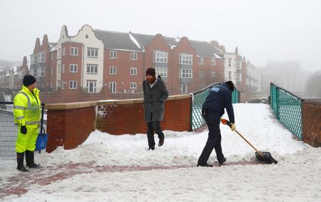 Council workers begin to clear snow besides the canal in Birmingham, Britain March 3, 2018. REUTERS/Phil Noble