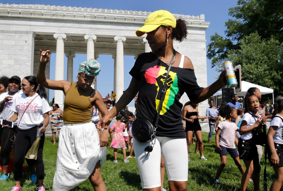 Takina Lee danced to music and joined a large line dance with friend Claude Michelle Aubourg, left, at the first Juneteenth celebration at Roger Williams Park Temple to Music in Providence, Rhode Island in 2019.