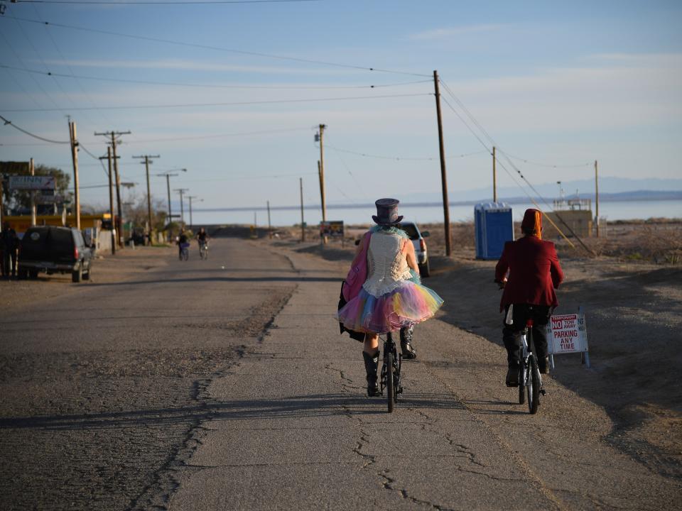 Attendees ride bicycles on the first day of the 2019 Bombay Beach Biennale, an art festival in Bombay Beach.