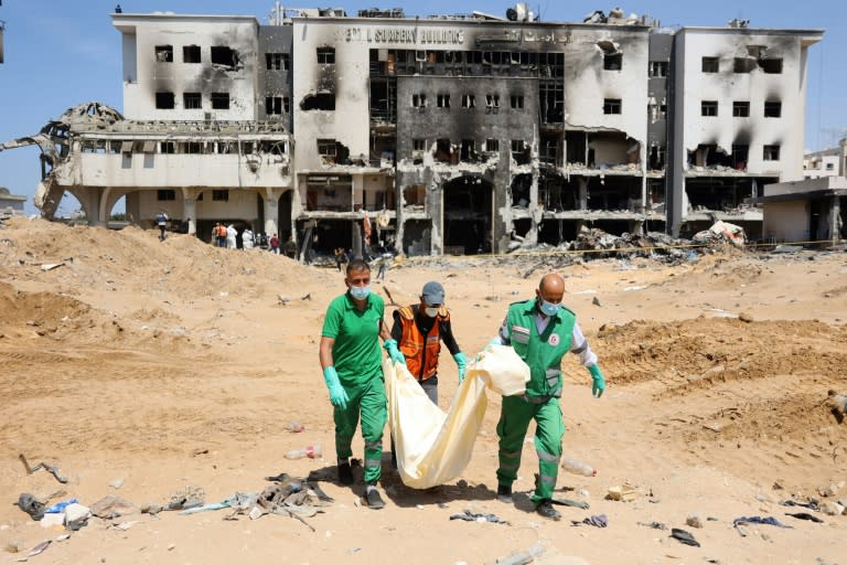 Des experts en médecine légale et membres de la défense civile palestiniens transportent les restes d'un corps dans le complexe hospitalier d'al-Chifa, dans la ville de Gaza, le 8 avril 2024, après le retrait de l'armée israélienne, sur fond de guerre entre Israël et le mouvement islamiste palestinien Hamas (-)