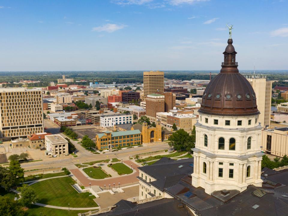 The copper dome shines in the urban area at the capitol building of Topeka, Kansas.