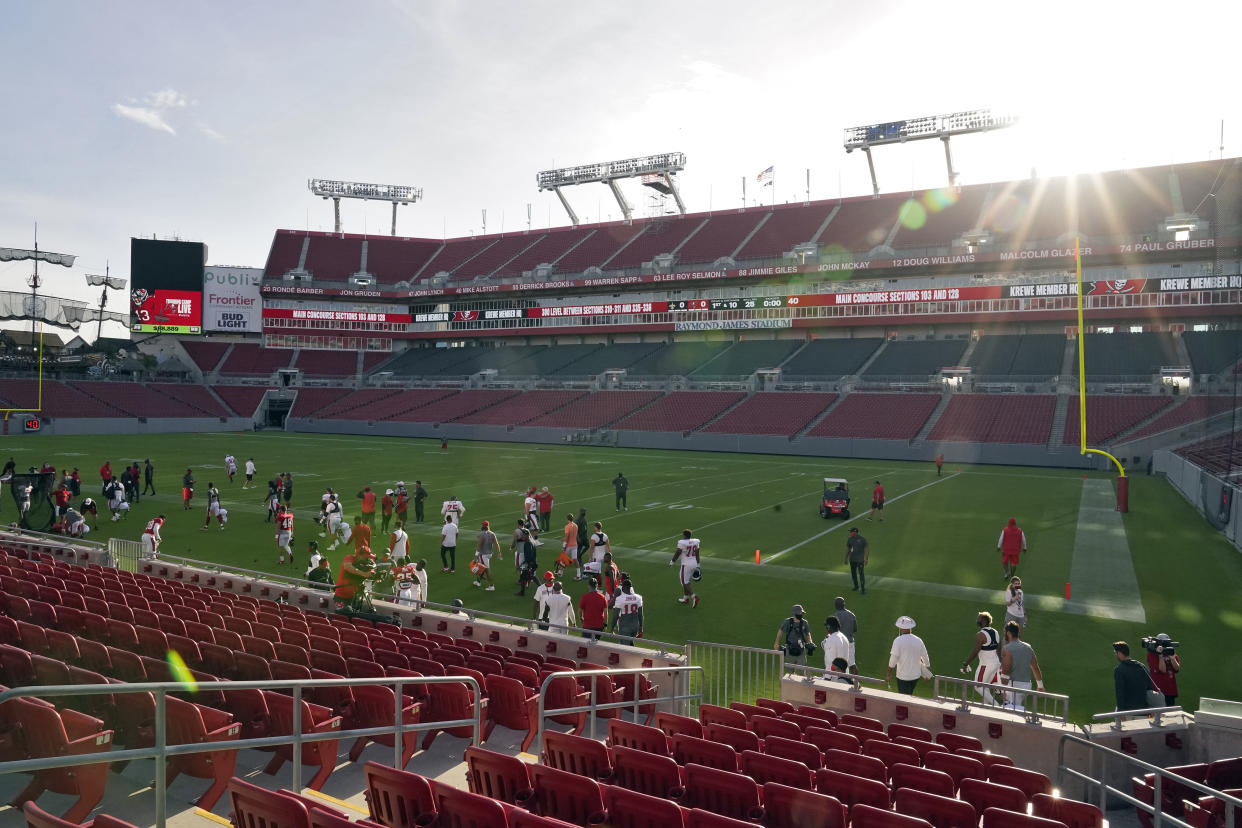 The sun rises over Raymond James Stadium as the Tampa Bay Buccaneers take the field for an NFL football training camp practice Friday, Aug. 28, 2020, in Tampa, Fla. (AP Photo/Chris O'Meara)
