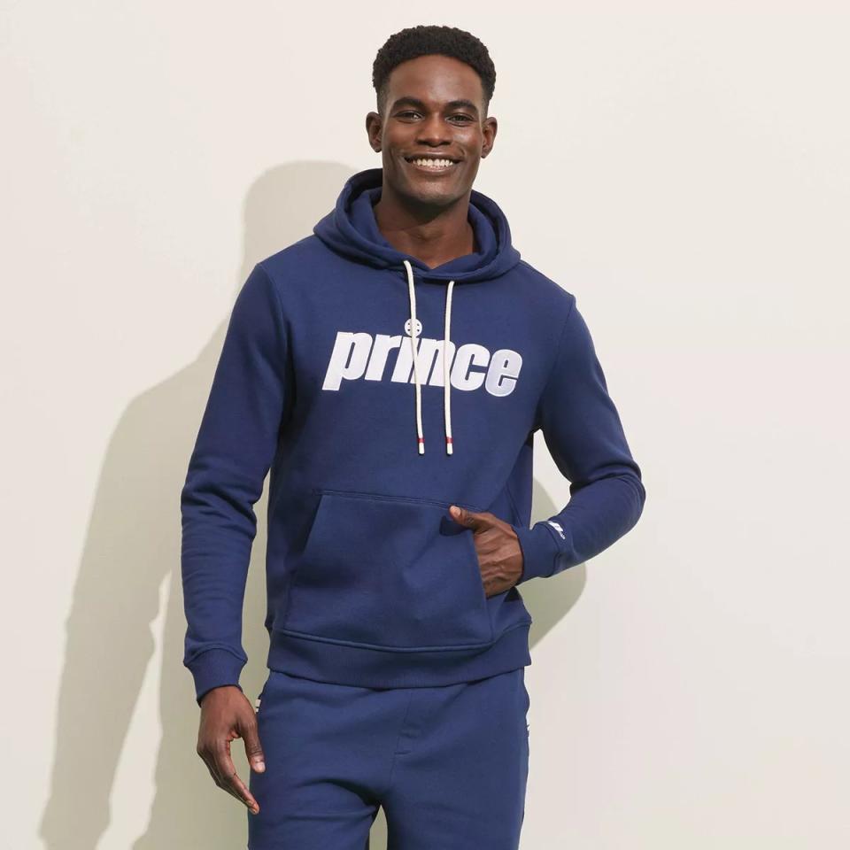 model wearing navy blue hoodie with white lettering and matching sweatpants