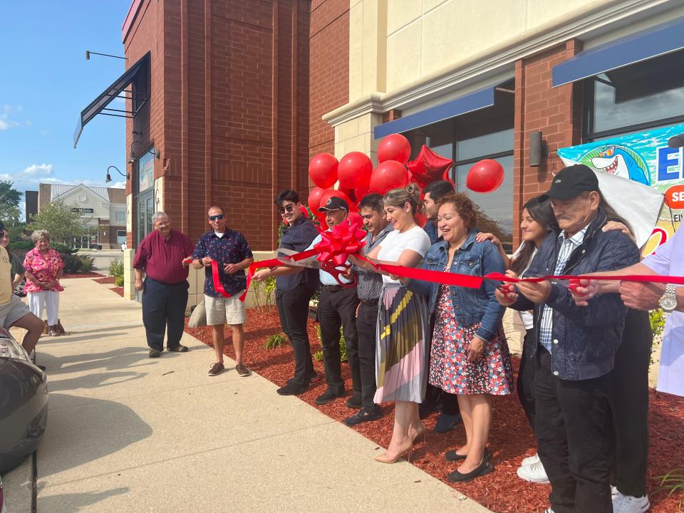 Liz Rebollar and her husband, Tollo Cruz, center, cut the ribbon Monday, July 17, 2023, during the grand opening event at their new business, El Vallarta Sports Bar and Grill. located just outside the CherryVale Mall in Cherry Valley.