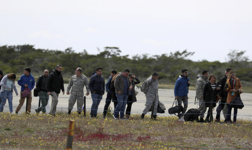 Relatives of passengers of a missing military plane arrive at an airbase in Punta Arenas, Chile, Wednesday, Dec. 11, 2019. Searchers using planes, ships and satellites were combing the Drake Passage on Tuesday, hunting for the plane carrying 38 people that vanished en route to an Antartica base. (AP Photo/Fernando Llano)