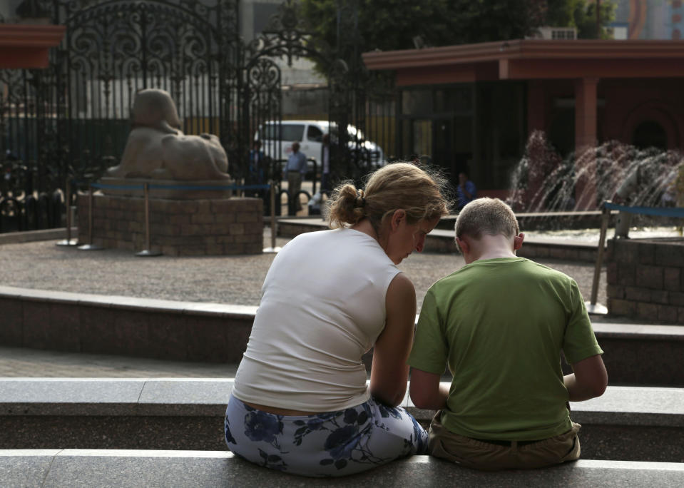 In this Wednesday, Oct. 30, 2013 photo, tourists visit the Egyptian Museum near Tahrir Square in Cairo, Egypt. The 111-year-old museum, a treasure trove of pharaonic antiquities, has long been one of the centerpieces of tourism to Egypt. But the constant instability since the 2011 uprising that toppled autocrat Hosni Mubarak has dried up tourism to the country, slashing a key source of revenue. Moreover, political backbiting and attempts to stop corruption have had a knock-on effect of bringing a de facto ban on sending antiquities on tours to museums abroad, cutting off what was once a major source of funding for the museum. (AP Photo/Nariman El-Mofty)