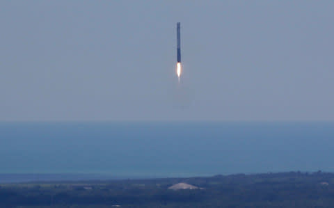 A Falcon 9 SpaceX rocket lands its leftover booster back at Cape Canaveral shortly after liftoff from pad 39A at the Kennedy Space Center in Cape Canaveral - Credit:  John Raoux/AP