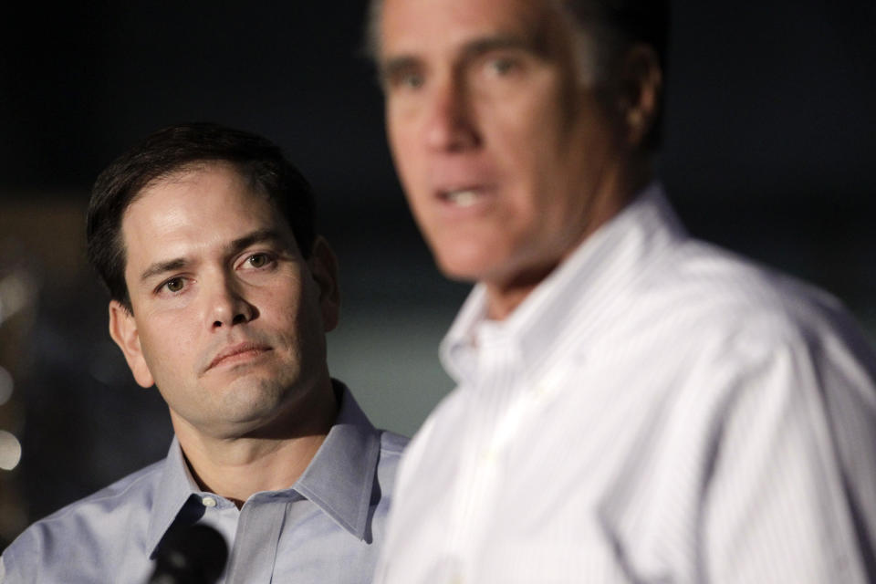 Sen. Marco Rubio, R-Fla. listens at left as Republican presidential candidate, former Massachusetts Gov. Mitt Romney speaks during a news conference prior to a town hall-style meeting in Aston, Pa., Monday, April 23, 2012. (AP Photo/Jae C. Hong)