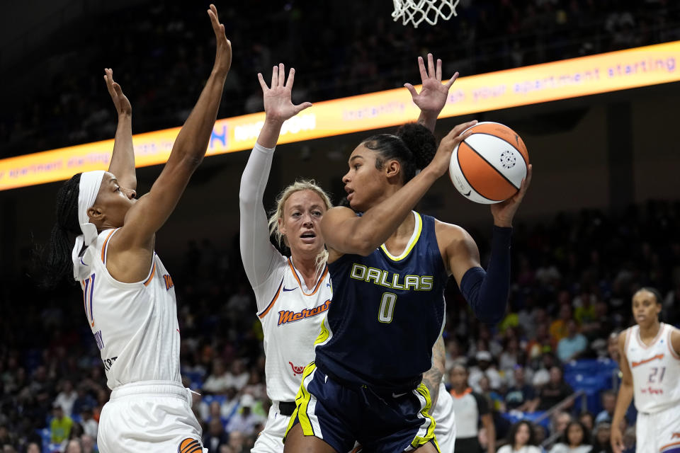 Dallas Wings forward Satou Sabally (0) looks to pass the ball as Phoenix Mercury's Shey Peddy (11) and Sophie Cunningham, center, defend during the first half of a WNBA basketball game Wednesday, June 7, 2023, in Arlington, Texas. (AP Photo/Tony Gutierrez)