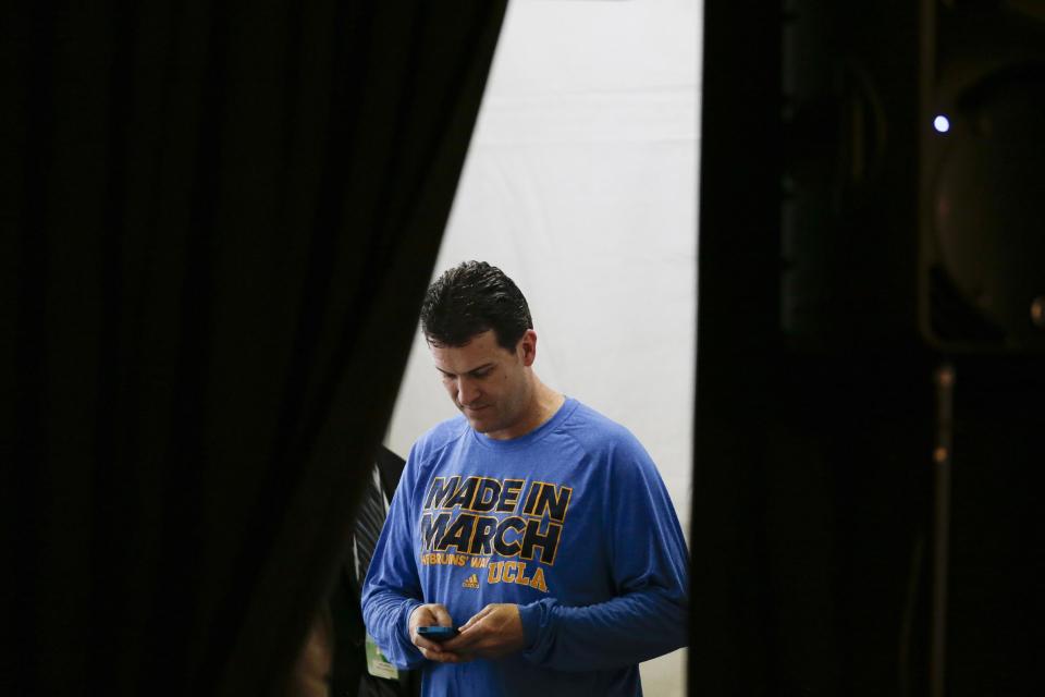 UCLA head coach Steve Alford enters text into his phone before a news conference during the NCAA men's college basketball tournament Saturday, March 22, 2014, in San Diego. UCLA faces Stephen F. Austin in a third-round game on Sunday. (AP Photo/Gregory Bull)