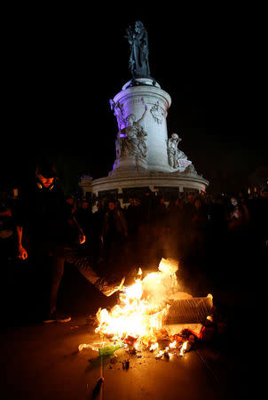 Youths burn campaign posters after partial results in the first round of 2017 French presidential election, on the Place de la Republique in Paris, France April 23, 2017. REUTERS/Jean-Paul Pellisier