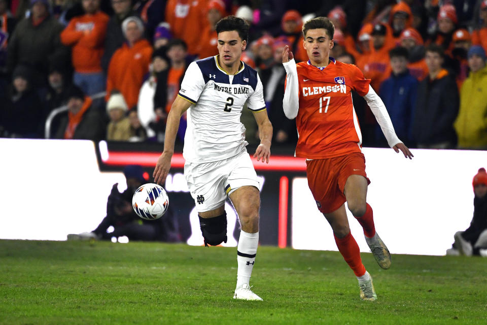 Notre Dame defender Mitch Ferguson (2) and Clemson forward Tyler Trimnal (17) chase the ball during the first half of the NCAA college soccer tournament championship game in Louisville, Ky., Monday, Dec. 11, 2023. (AP Photo/Timothy D. Easley)