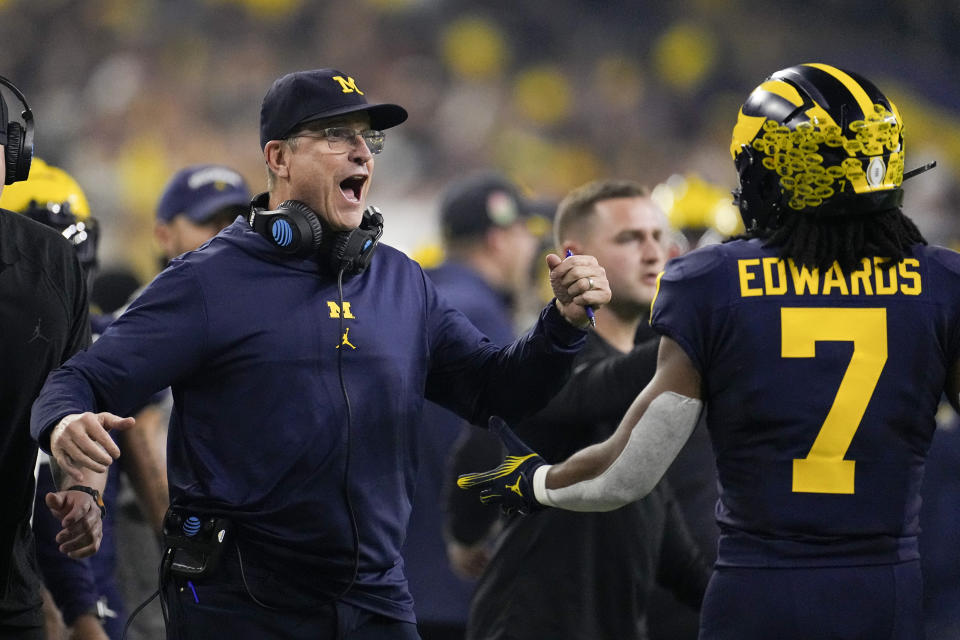 Michigan running back Donovan Edwards celebrates after scoring with head coach Jim Harbaugh during the first half of the national championship NCAA College Football Playoff game against Washington Monday, Jan. 8, 2024, in Houston. (AP Photo/David J. Phillip)