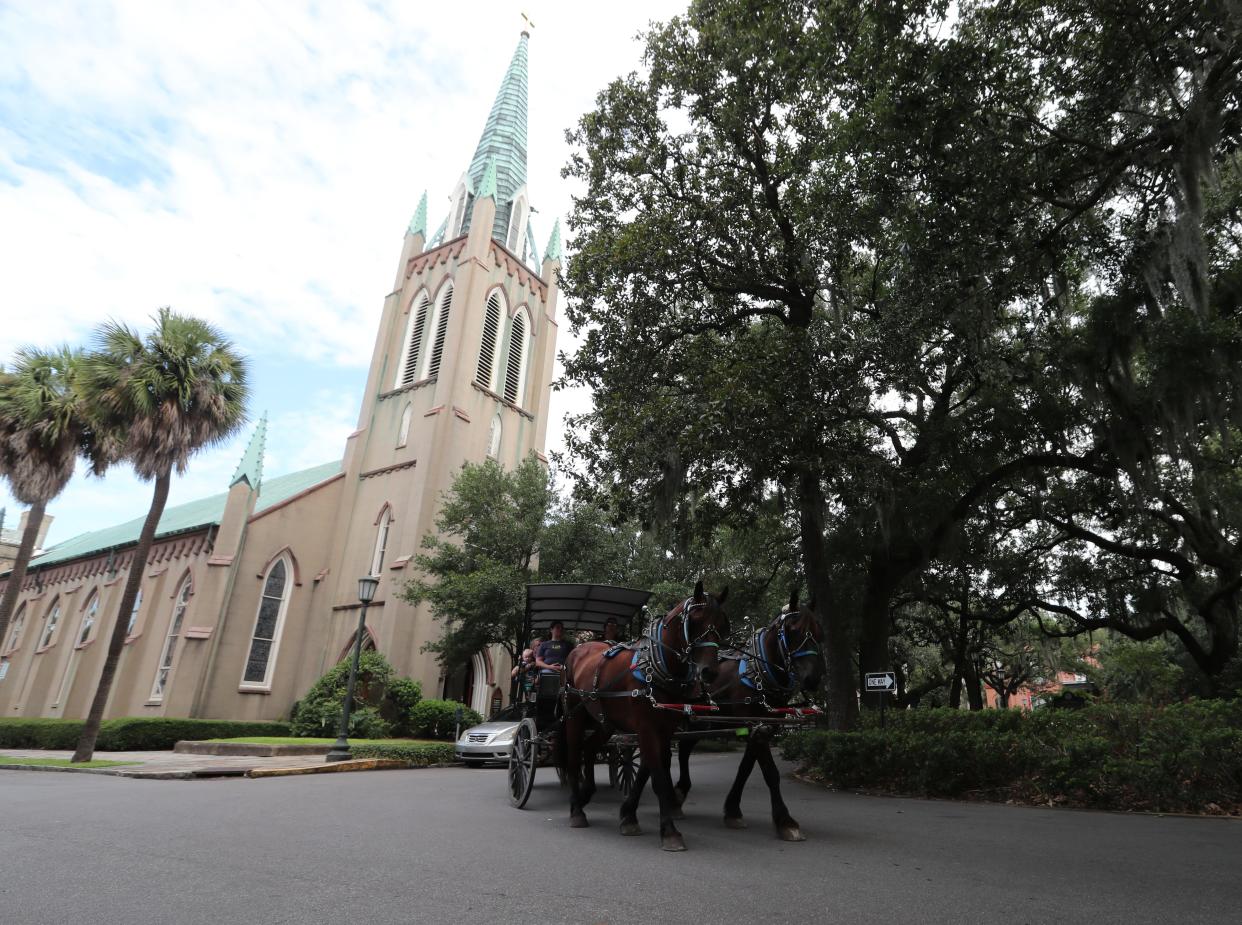 A carriage tour moves along Bull Street past St. John's Episcopal Church. St. John's can be found in the opening scene of "Forest Gump" as a feather floats over Madison Square.