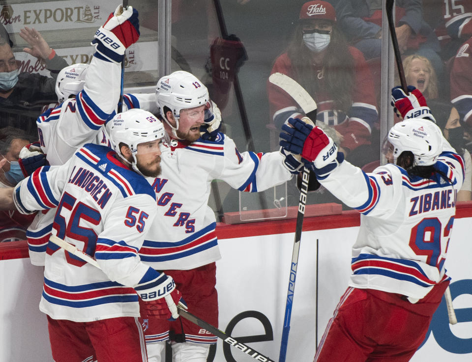 New York Rangers' Alexis Lafreniere (13) celebrates with teammates after scoring against the Montreal Canadiens during the third period of an NHL hockey game Saturday, Oct. 16, 2021, in Montreal. (Graham Hughes/The Canadian Press via AP)