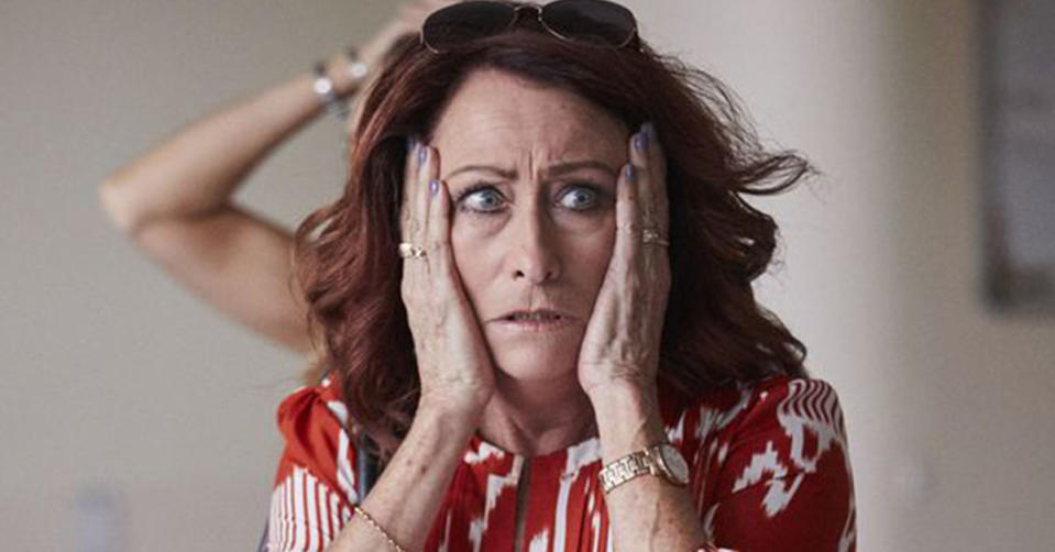 Home and Away star Lynne McGranger puts her hands on her face as she looks shocked