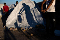 <p>A Pakistani migrant wrings out a t-shirt near the Souda refugee camp by the beach, where hundreds of refugees and other migrants live in makeshift tents on Chios island, Greece, June 9, 2017 . On World Refugee Day, more than 60,000 refugees and migrants are still stranded in Greece in a process barely moving: Forward to other countries of the European Union, or back to Turkey under a deportation deal launched 15 months ago. (Photo: Petros Giannakouris/AP) </p>