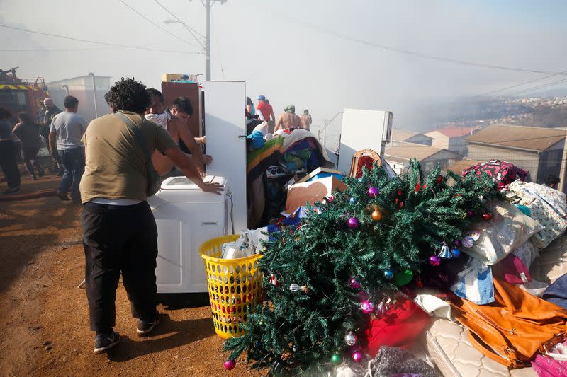 People gather personal belongings during an evacuation as a fire continues in Valparaiso