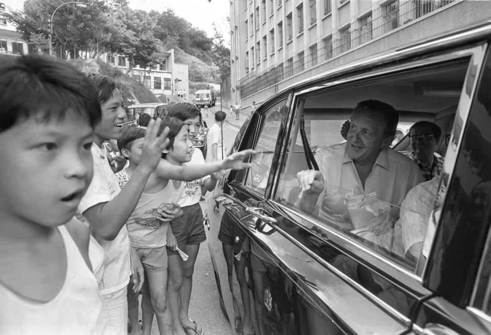 麥理浩卸下西裝，立刻重拾親民一面。圖為 1977 年 7 月，麥理浩乘港督專車到訪石硤尾邨。 (Photo by Chan Kiu/South China Morning Post via Getty Images)