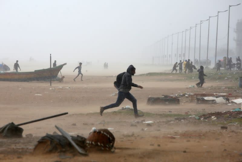 People run from the Marina beach after sudden heavy rains before Cyclone Nivar's landfall, in Chennai