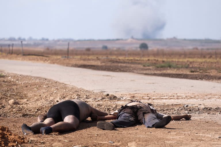 Dos cadáveres yacen en el suelo cerca de una carretera en Kfar Aza, al sur de Israel, en la frontera con la Franja de Gaza, el 10 de octubre de 2023