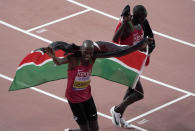 Timothy Cheruiyot of Kenya, left, celebrates after winning the gold medal in the men's 1500 meter final at the World Athletics Championships in Doha, Qatar, Sunday, Oct. 6, 2019. (AP Photo/Morry Gash)