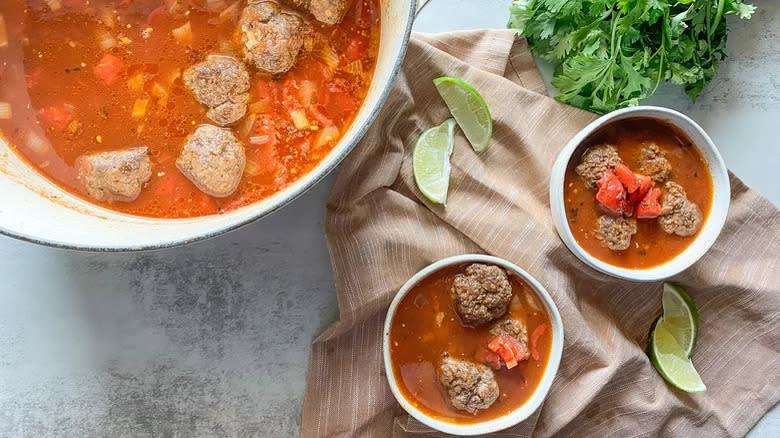 Meatball soup in pot with two bowls