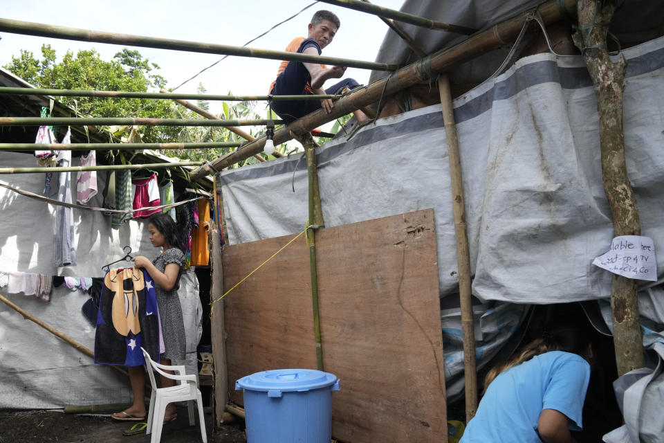 An evacuee makes additional shelter for his family at an evacuation center in Malilipot town, Albay province, northeastern Philippines, Thursday, June 15, 2023. Thousands of residents have left the mostly poor farming communities within a 6-kilometer (3.7-mile) radius of Mayon's crater in forced evacuations since volcanic activity spiked last week. (AP Photo/Aaron Favila)