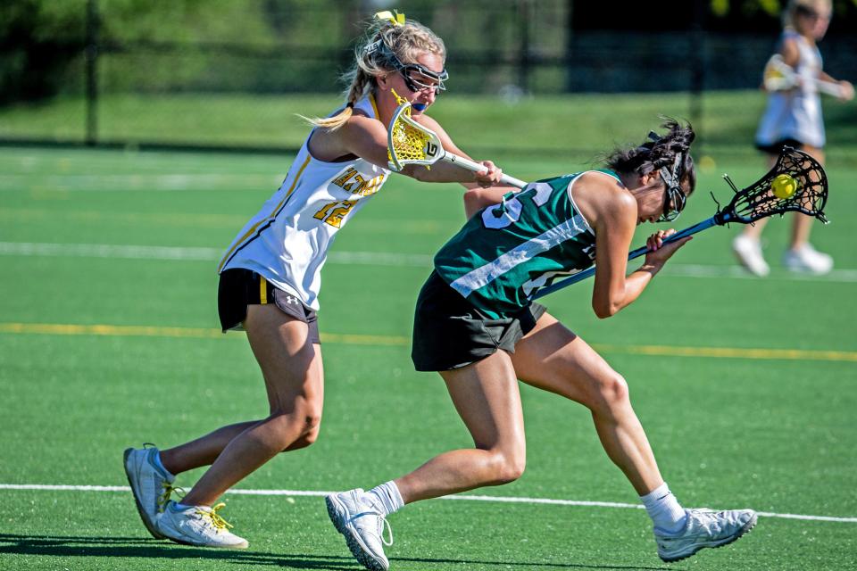 Tower Hill High School senior Brianna Chi battles to keep control of the battle against Tatnall School junior Ivy Qualls (12) during the girls lacrosse game at the Tatnall turf field in Greenville, Thursday, April 13, 2023. Tatnall won 23-8.