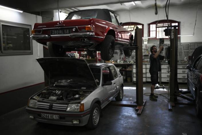 Mechanic Frederic Mistre works on a combustion engine car at a garage in Marseille, southern France, Wednesday, June 8, 2022. The European Parliament is voting Wednesday on deeper emission cuts by power plants, factories, planes and cars. The legislative package, which includes a proposed EU ban on combustion-engine cars in 2035, aims to slash Europe's greenhouse gases by 55% in 2030 compared with 1990 levels and put the bloc on a path to climate-neutrality by mid-century. (AP Photo/Daniel Cole)